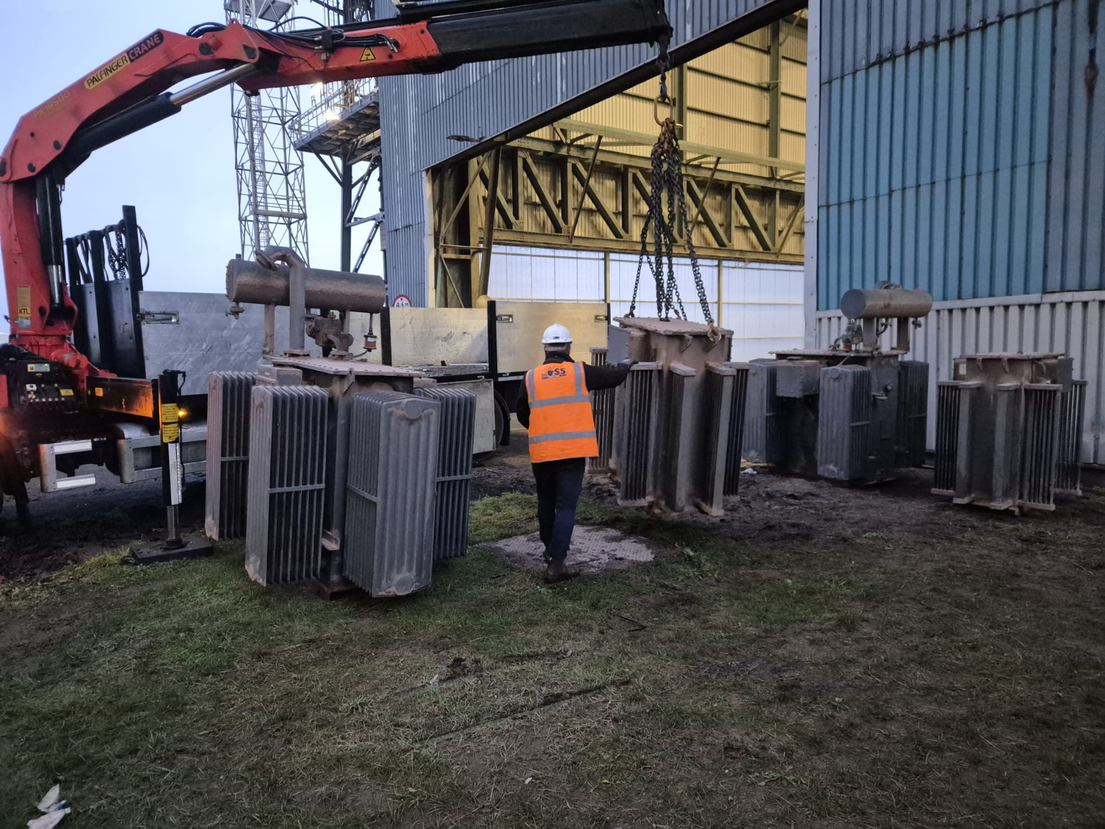 OSS operative directing a transformer lift at dusk